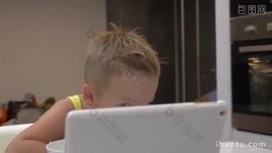 小男孩在厨房<strong>吃饭</strong>，在平板电脑上看卡通片，<strong>吃饭</strong>和娱乐